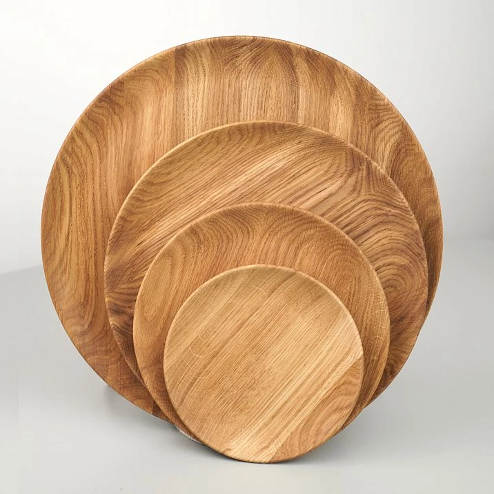 Several wooden plates of different sizes, photographed in profile.